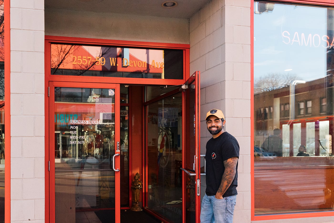 Sneh Sukhadia holds open the door to his family's sweet shop