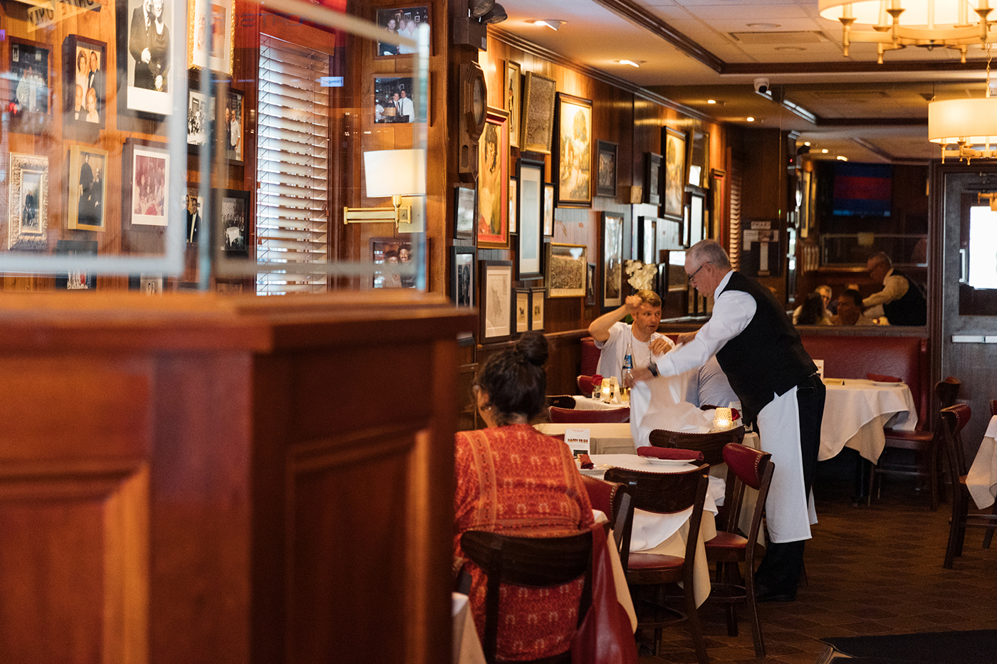 A server attends to customers at a table in a restaurant