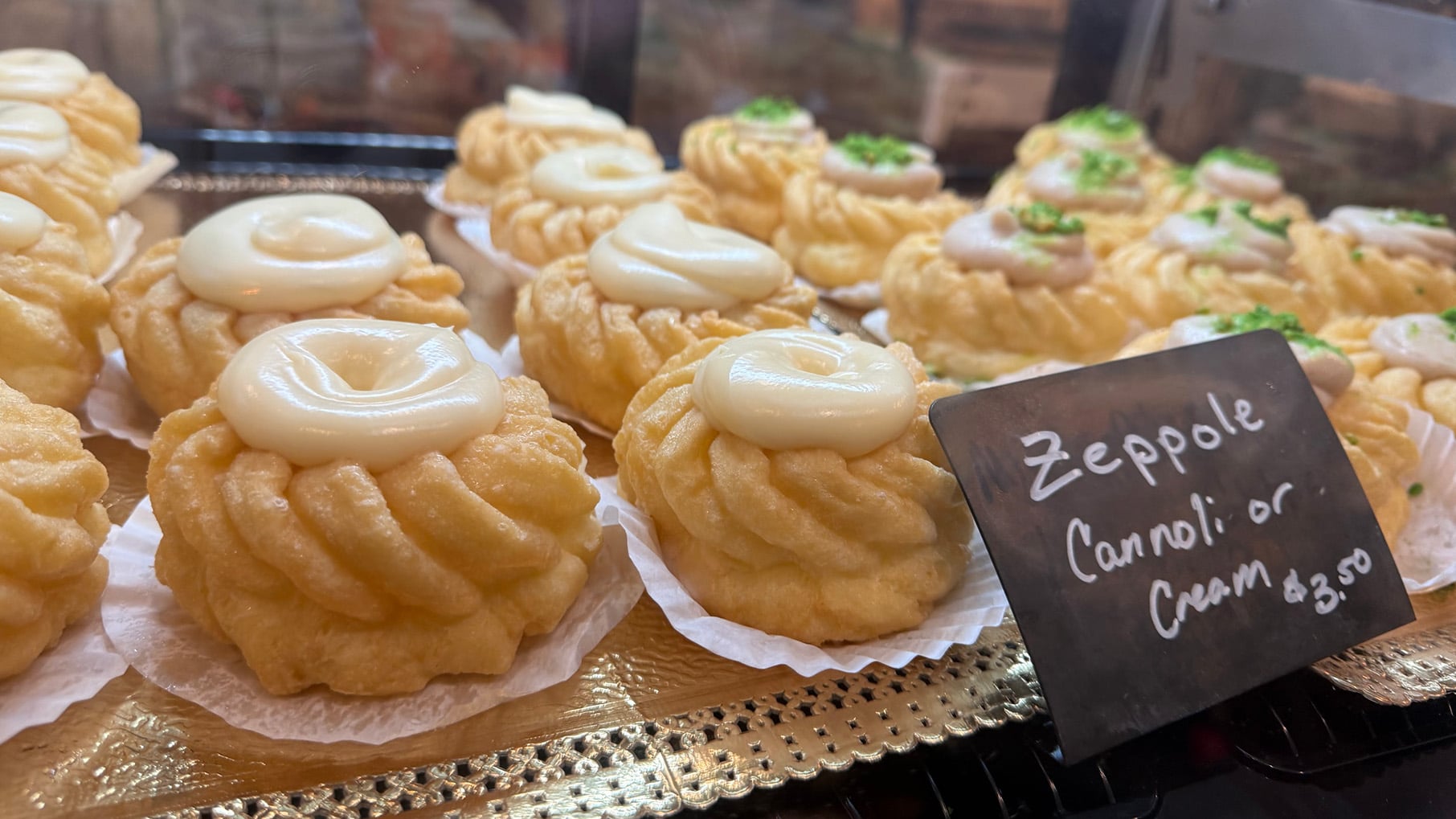 Rows of zeppole in a glass bakery case