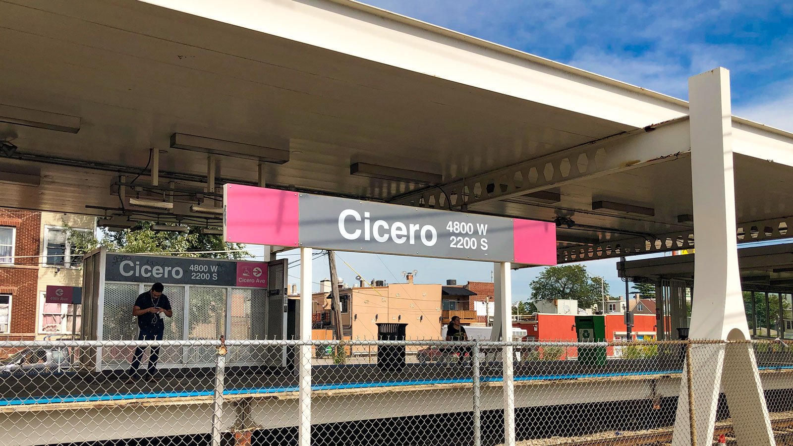 The Cicero 'L' platform with a woman sitting and man standing waiting for the train.