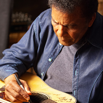 Charley Pride signs a Martin D-28 guitar. Pride is among the 76 of the 101 country music artists interviewed for the series who signed two Martin D-28 guitars. Photo: Courtesy of Craig Mellish