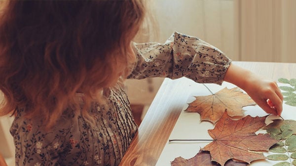 Child creating leaf art.