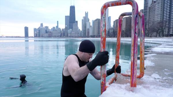A man climbs out of the lake in Chicago during winter