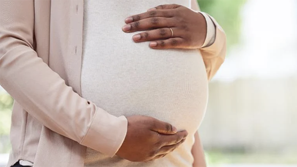 Credit: iStock A close-up of a woman holding her pregnancy bump