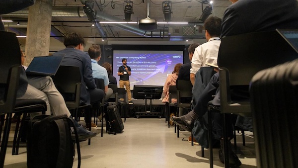 Manish Singh, co-founder and CEO of quantum tech company memQ, speaks to representatives of dozens of Japanese quantum business at a June 10, 2025, event in Chicago. Credit: Andrew Adams / Capitol News Illinois A man presents to a crowd in front of a screen