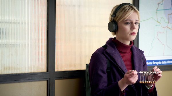Patience Evans spots patterns in her job in the Criminal Records Office, but her autism makes it difficult for her to work with others. Credit: Robert Viglasky for Eagle Eye Drama Patience sits with headphones on and a purple coat holding a puzzle