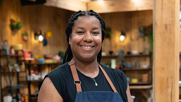 Brie Jamieson learned Caribbean recipes from her relatives while growing up in Evanston. Credit: The Great American Recipe Brie Jamieson smiles in an apron