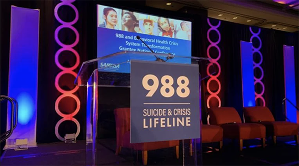 988 Suicide and Crisis Lifeline national conference in Chicago on April 30, 2024. (Eunice Alpasan / WTTW News) A sign reading 988 Suicide and Crisis Line attached to a podium at the 988 Suicide and Crisis Lifeline national conference in Chicago in April 2024
