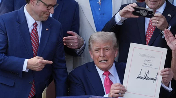 House Speaker Mike Johnson points to the "Big Beautiful Bill," held up by President Donald Trump. Credit: AP Photo / Evan Vucci