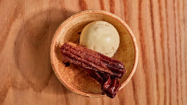 A churro in a bowl with ice cream on a table