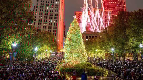 Chicago's 2024 tree lighting ceremony in Millennium Park, with a large, brightly lit Christmas tree at the center of the photograph