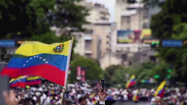 A gathering with a Venezuelan flag above it