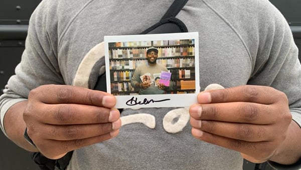 Harold Moore, 40, of Austin poses with a polaroid of him inside the Criterion Mobile Closet on Oct. 17, 2025. He picked out Mira Nair’s “Mississippi Masala” (1991), a Robert Downey Sr. film collection and a Melvin Van Peebles film collection. (Eunice Alpasan / WTTW News) Harold Moore, 40, of Austin poses with a polaroid of him inside the Criterion Mobile Closet on Oct. 17, 2025.
