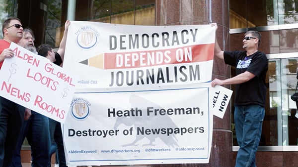 Journalists and activists protest outside the headquarters of hedge fund Alden Global Capital in 2019. Credit: Rick Goldsmith / Stripped for Parts: American Journalism on the Brink People hold up banners in a protest