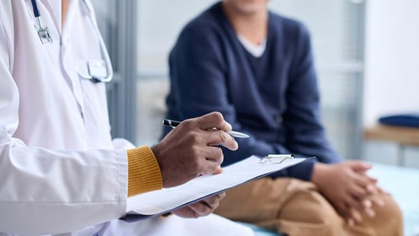 Credit: mediaphotos / iStock A stock image of a person sitting on an exam table while a doctor takes notes on a clipboard