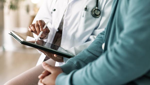 Credit: Jacob Wackerhausen / iStock A stock image of a doctor pointing to a tablet next to a patient