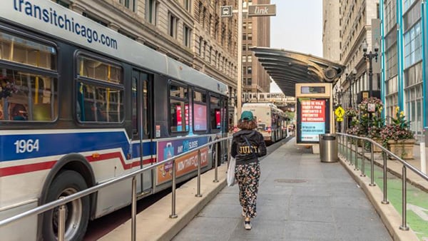 A person walks along side a CTA bus in Chicago's Loop