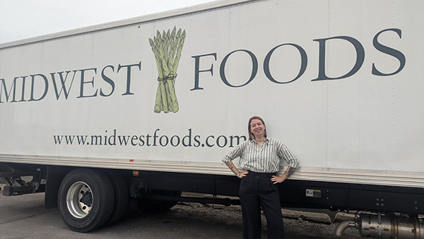 Alex Frantz poses in front of a truck labelled Midwest Foods