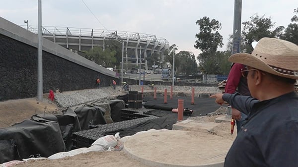 A man in a cowboy hat looks at construction