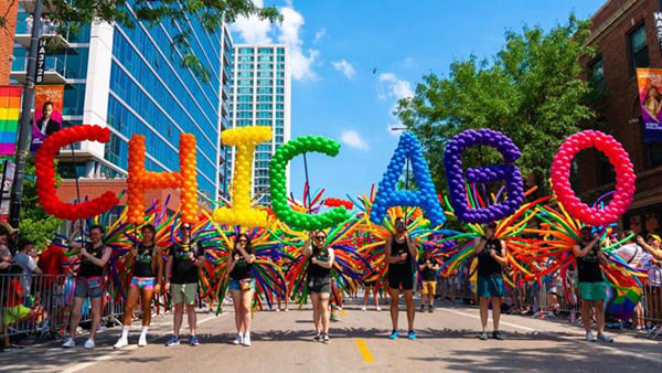 Rainbow balloons spelling out CHICAGO across a street during the Chicago Pride Parade