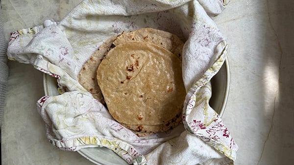 Roti piled in a dish with towels