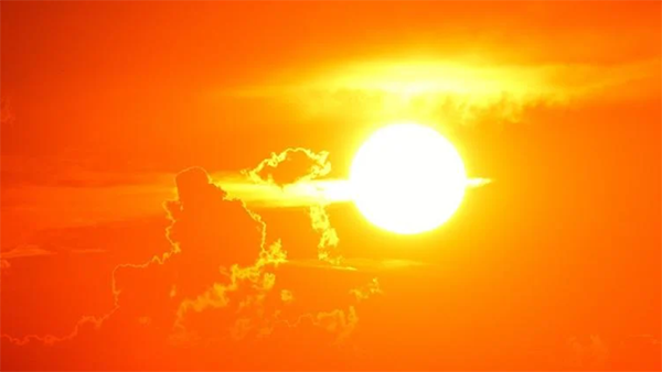 The sun set against a bright orange sky