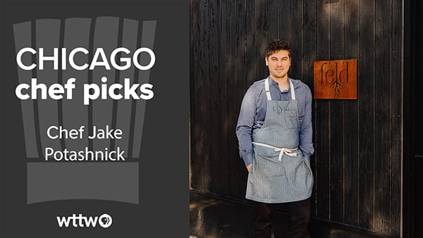 Jake Potashnick stands outside his restaurant next to the sign in an apron