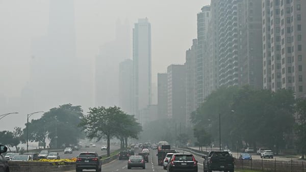 The iconic John Hancock Center is reduced to a faint silhouette behind a thick shroud of Canadian wildfire smoke as vehicles head southbound on DuSable Lake Shore Drive near the Gold Coast neighborhood on Thursday, July 16, 2026. (Victor Hilitski / WTTW News)