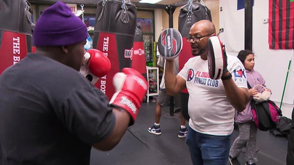 Two people practicing in a boxing gym