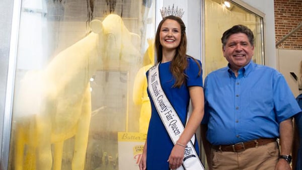 Illinois State Fair Queen Krista Phillips and Gov. JB Pritzker pose with the 2026 Illinois State Fair butter cow.