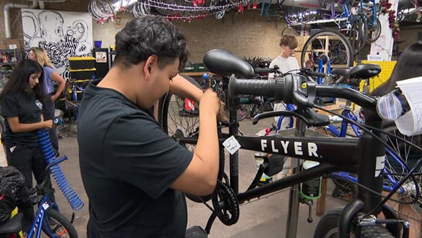 A teenager works on a bike
