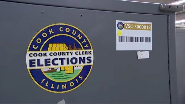 A metal ballot box with a logo on the side reading Cook County Clerk Elections