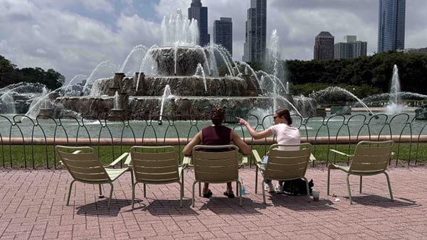 Two people sitting in chairs in front of Buckingham Fountain