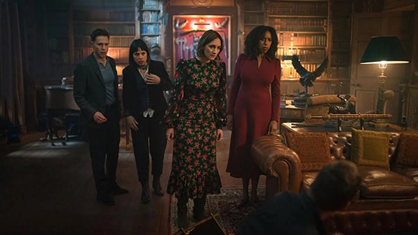 Becks and a group of people stand in an old library looking in shock at something