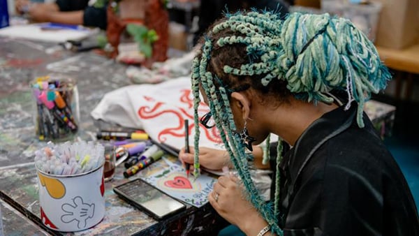 A student sitting at a table drawing 
