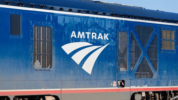 An Amtrak logo on the side of a blue train is pictured in a stock image