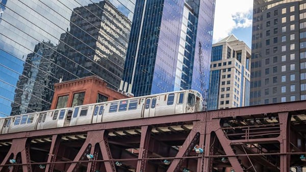 A CTA train on an elevated track in downtown Chicago, with skyscrapers in the background