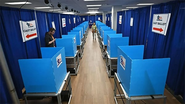 Lines of blue ballot boxes in between blue curtains