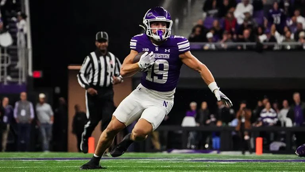 A Northwestern football player runs with the football