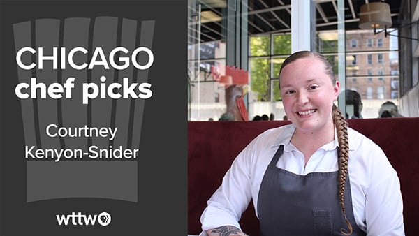 Courtney Kenyon-Snider smiles in a restaurant while sitting with an apron on
