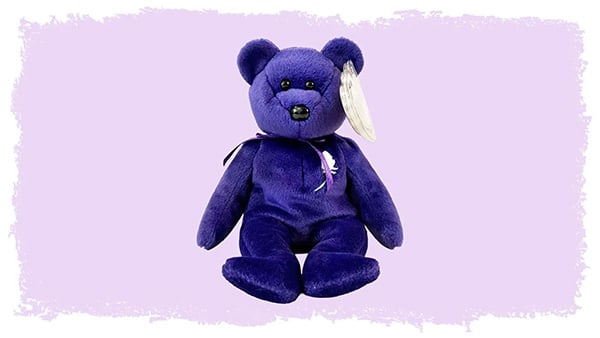 A purple Beanie Baby sits on a lilac background