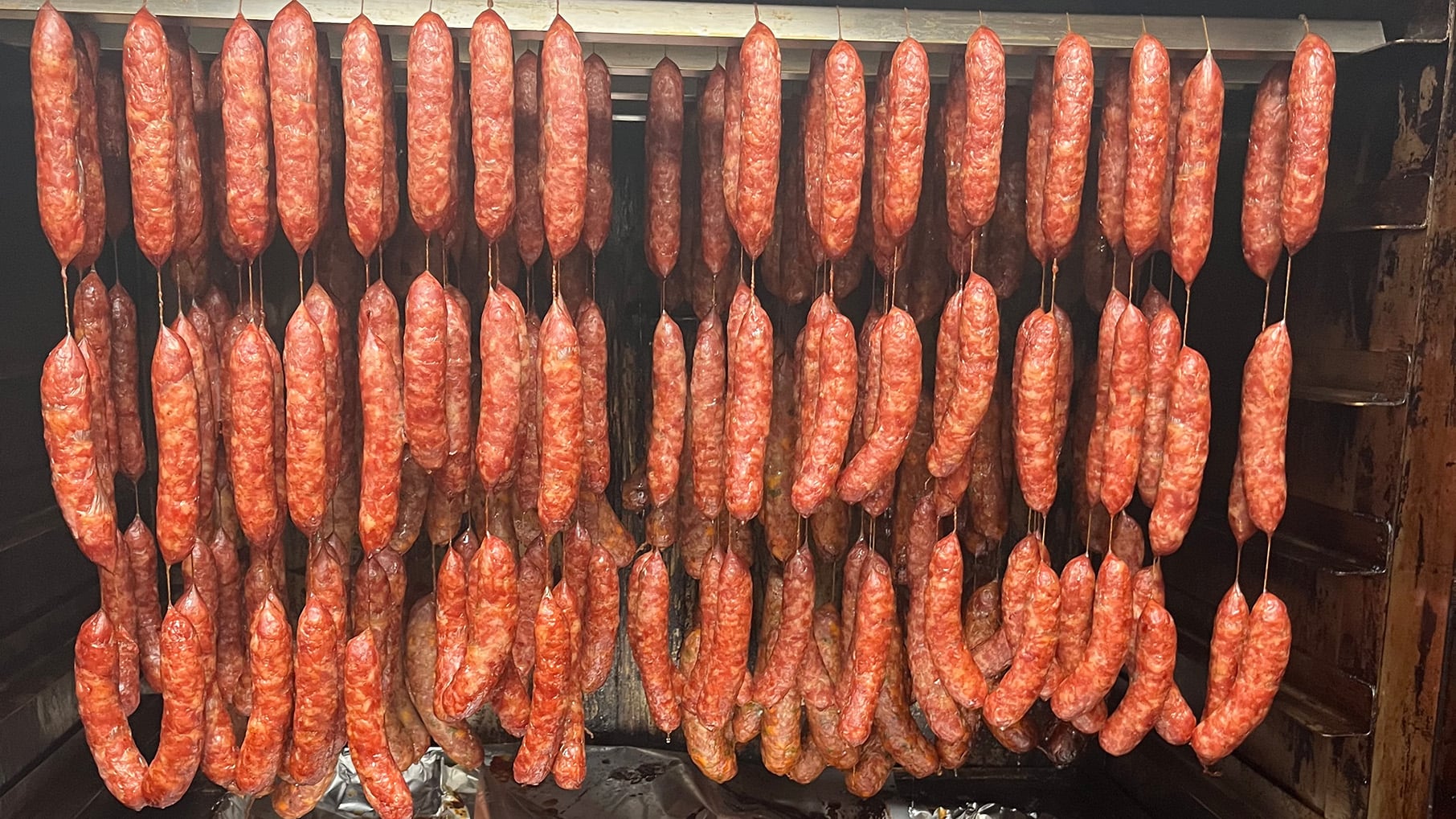 Sausages hang in a smoker