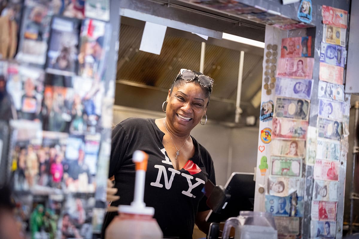 Evelyn Morris with a large smile looking out of the ordering window