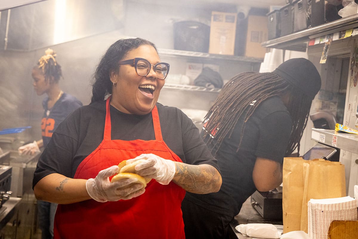 Poochie wearing a red apron holding hamburger buns while laughing