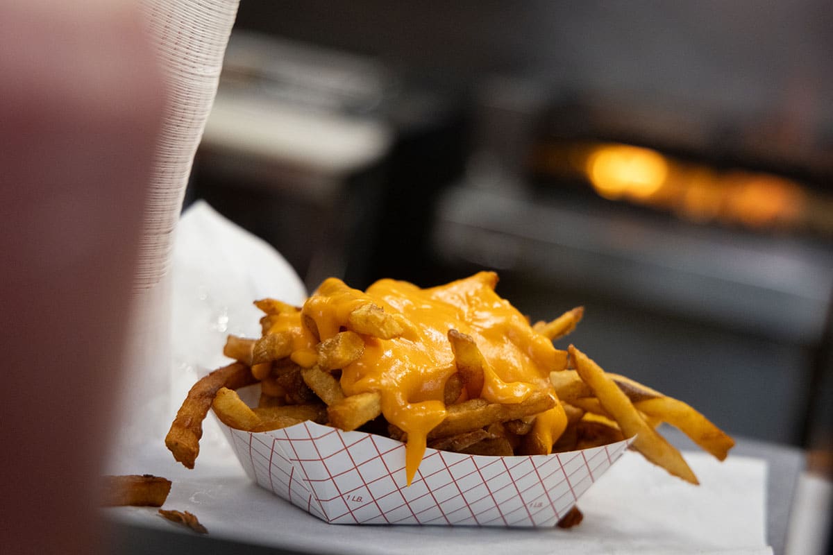 Closeup of a cardboard container of cheese fries