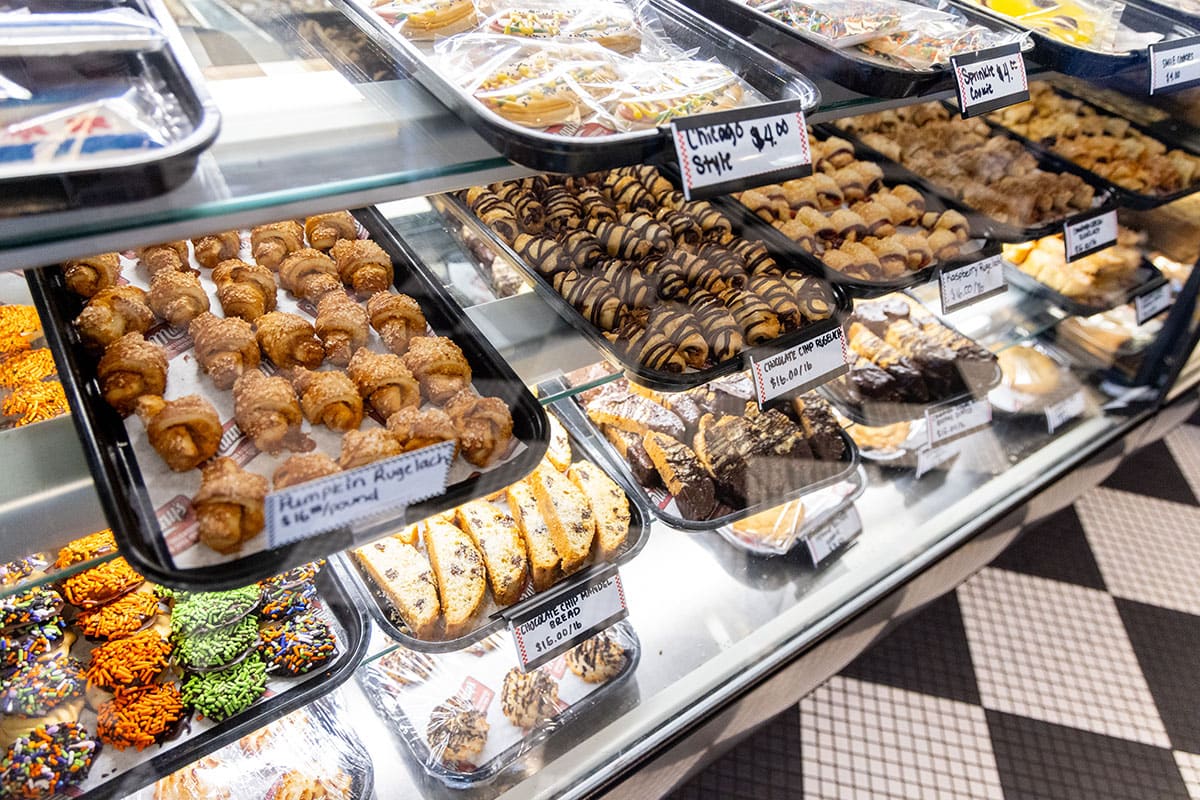 A display case filled with various pastries and desserts, showcasing a colorful assortment.