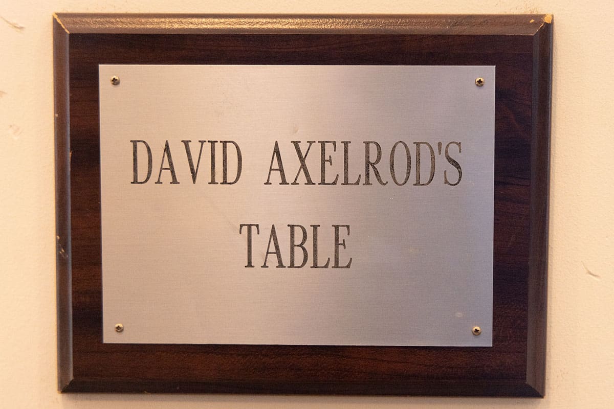 Plaque displaying "DAVID AXELROD'S TABLE" on a wooden background.