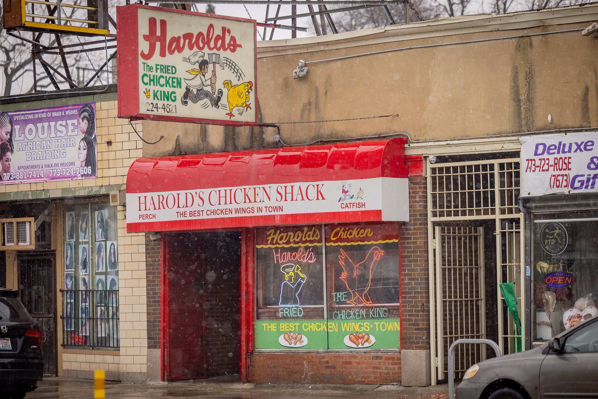 The signage in front of Harold's Chicken Shack in a light snow