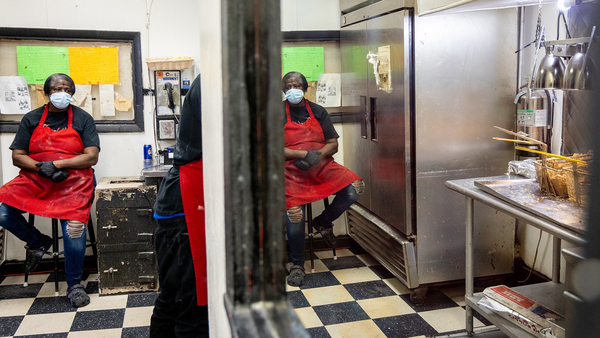 Shenaurlt sitting in the kitchen weaing a red smock