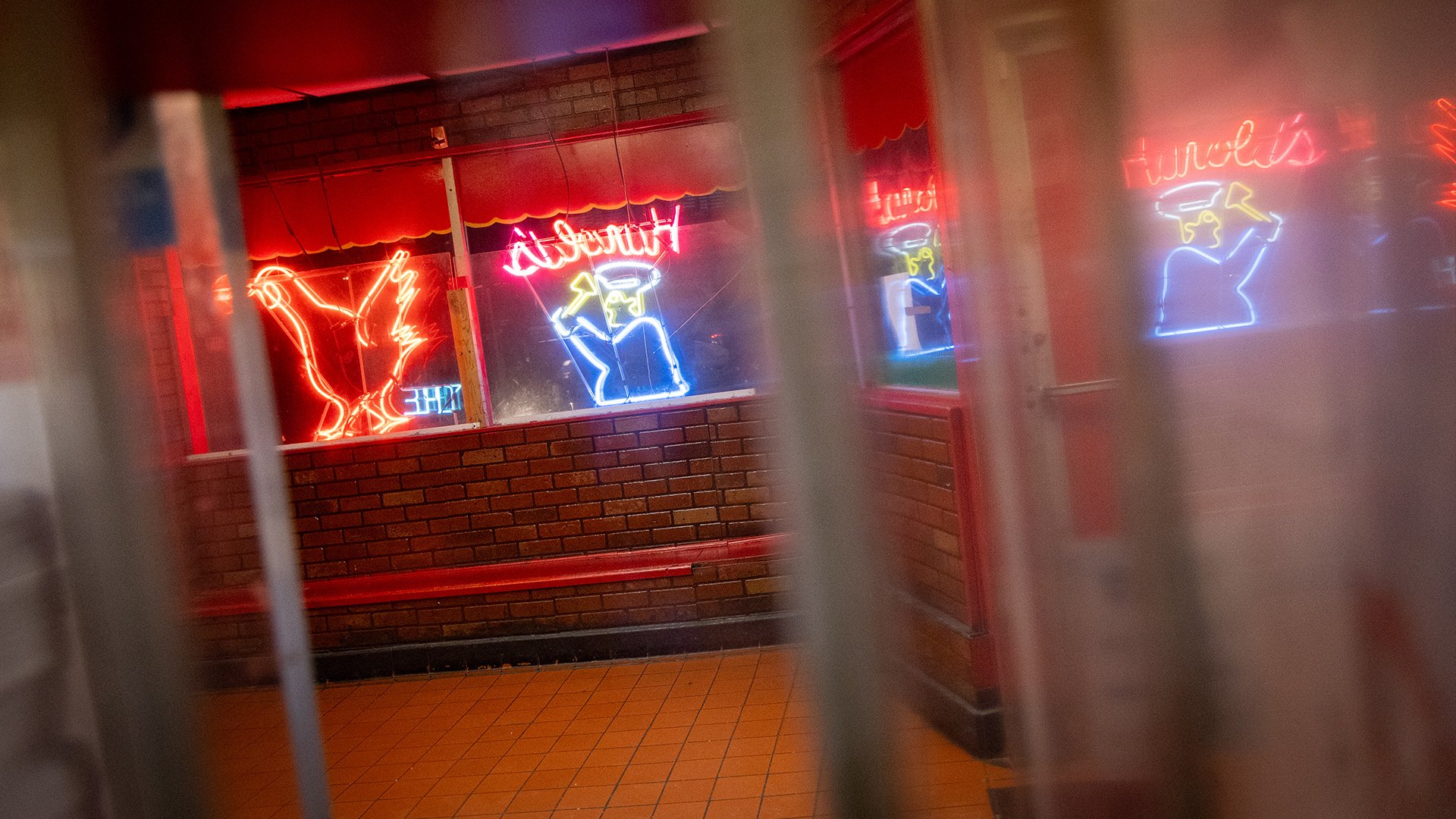 Neon signage in the restaurant showing a man with an axe chasing a chicken